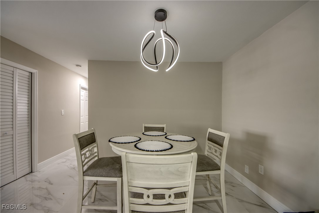 2544 First Street, Unit 107 Fort Myers, FL 33901 - Photo 12 of 35 a dining room with table chairs and wooden floor