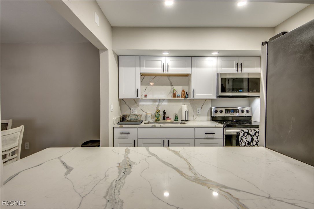 2544 First Street, Unit 107 Fort Myers, FL 33901 - Photo 17 of 35 a kitchen with a stove top oven and cabinets