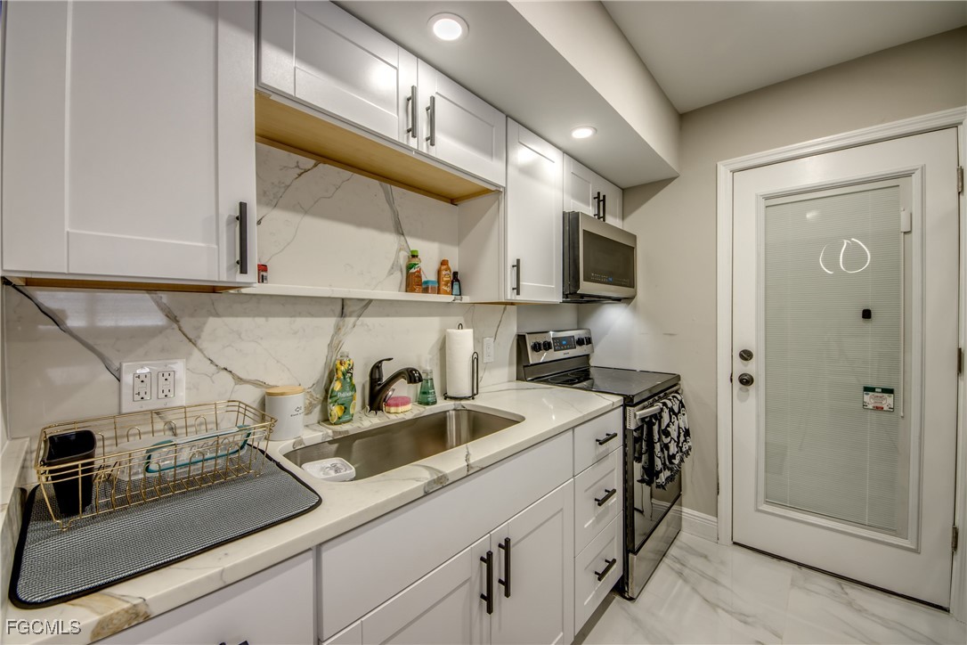 2544 First Street, Unit 107 Fort Myers, FL 33901 - Photo 20 of 35 a kitchen with stainless steel appliances granite countertop a sink stove and cabinets