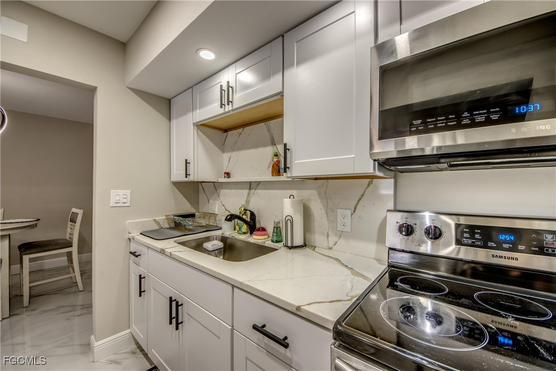 2544 First Street, Unit 107 Fort Myers, FL 33901 - Photo 22 of 35 a kitchen with a stove and a cabinets