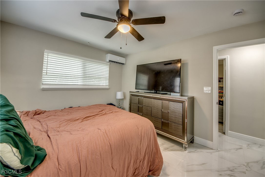 2544 First Street, Unit 107 Fort Myers, FL 33901 - Photo 25 of 35 a bedroom with a bed and a flat screen tv