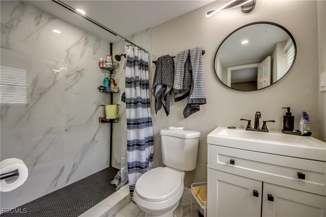 2544 First Street, Unit 107 Fort Myers, FL 33901 - Photo 28 of 35 a bathroom with a toilet sink and mirror