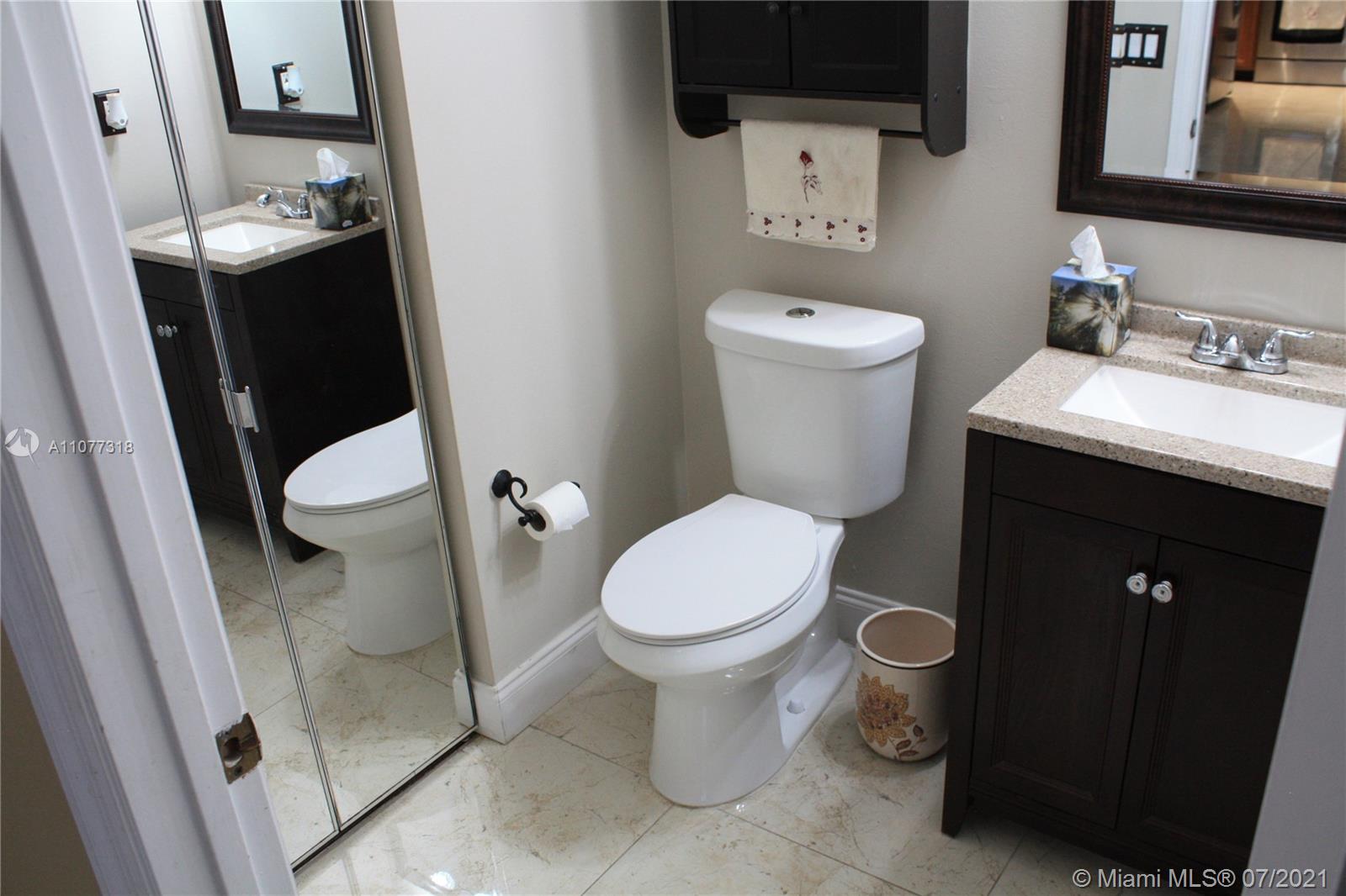 11352 Roundelay Road Cooper City, FL 33026 - Photo 13 of 30 a white toilet sitting next to a bathroom sink
