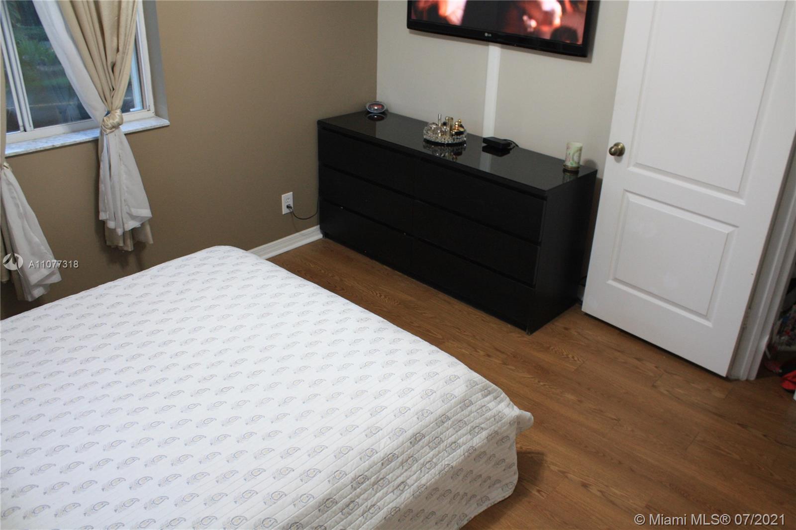 11352 Roundelay Road Cooper City, FL 33026 - Photo 24 of 30 a bedroom with a bed and a mirror