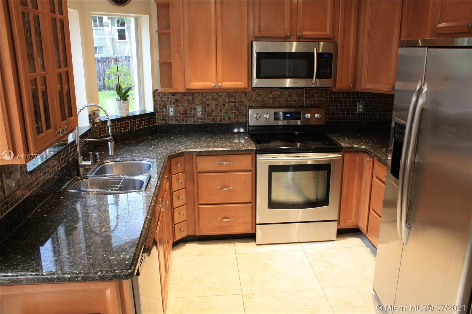 11352 Roundelay Road Cooper City, FL 33026 - Photo 10 of 30 a kitchen with stainless steel appliances granite countertop a stove a microwave and a sink