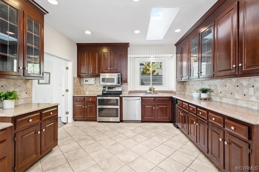 14324 Regatta Pointe Road Midlothian, VA 23112 - Photo 26 of 50 a large kitchen with stainless steel appliances granite countertop a stove a sink dishwasher a refrigerator and wooden cabinets with wooden floor