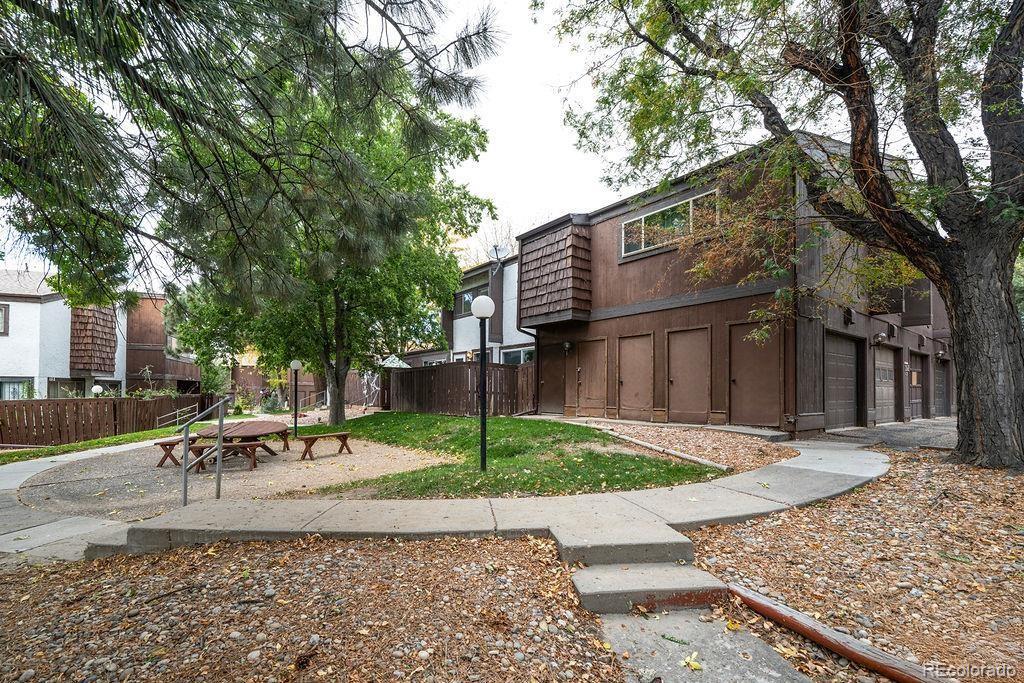 112 Scotland Road, Unit F Pueblo, CO 81001 - Photo 12 of 39 a view of a patio with a table and chairs and couches with large trees