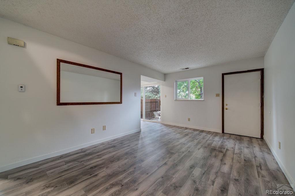 112 Scotland Road, Unit F Pueblo, CO 81001 - Photo 16 of 39 a view of an empty room with wooden floor and a window