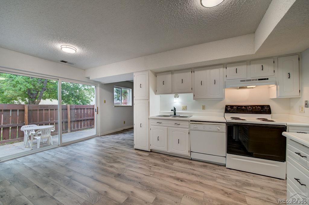 112 Scotland Road, Unit F Pueblo, CO 81001 - Photo 18 of 39 a kitchen with granite countertop white cabinets and white appliances