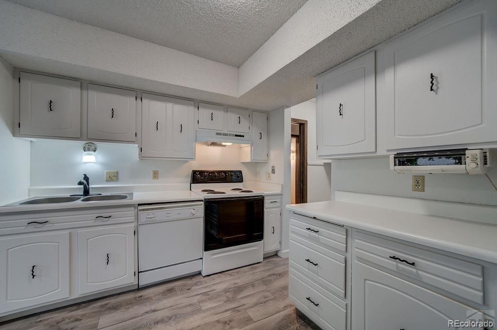 112 Scotland Road, Unit F Pueblo, CO 81001 - Photo 25 of 39 a kitchen with cabinets stainless steel appliances a sink and wooden floor