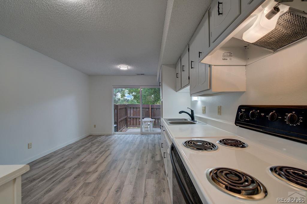 112 Scotland Road, Unit F Pueblo, CO 81001 - Photo 26 of 39 a kitchen with a stove a refrigerator and wooden floor