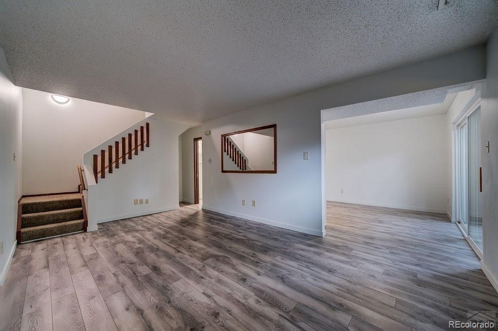 112 Scotland Road, Unit F Pueblo, CO 81001 - Photo 6 of 39 a view of an empty room with wooden floor and stairs