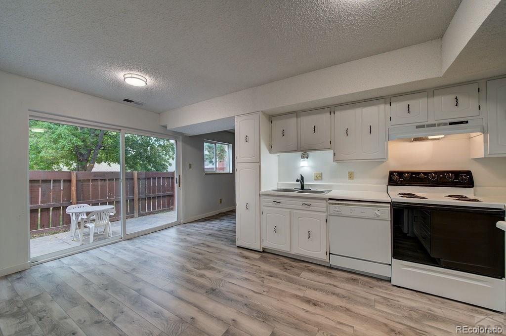 112 Scotland Road, Unit F Pueblo, CO 81001 - Photo 7 of 39 a kitchen with stainless steel appliances granite countertop a stove a sink and a refrigerator