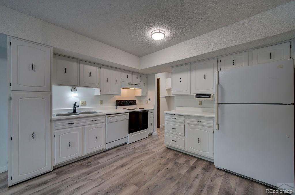 112 Scotland Road, Unit F Pueblo, CO 81001 - Photo 8 of 39 a kitchen with granite countertop cabinets appliances and wooden floor