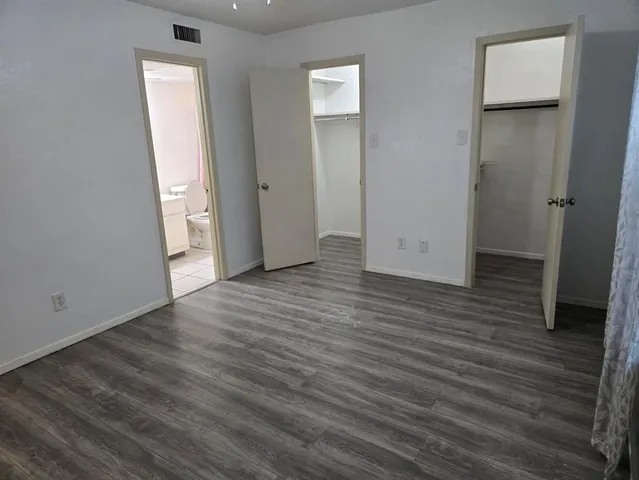 an empty room with wooden floor and closet