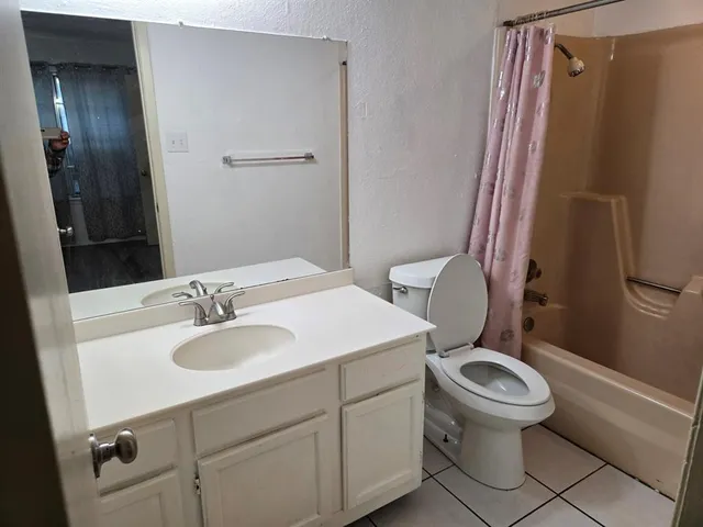 a bathroom with a granite countertop toilet sink and mirror