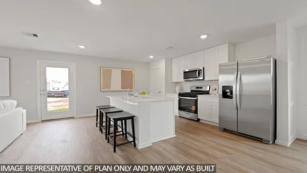 a kitchen with a refrigerator and a stove top oven