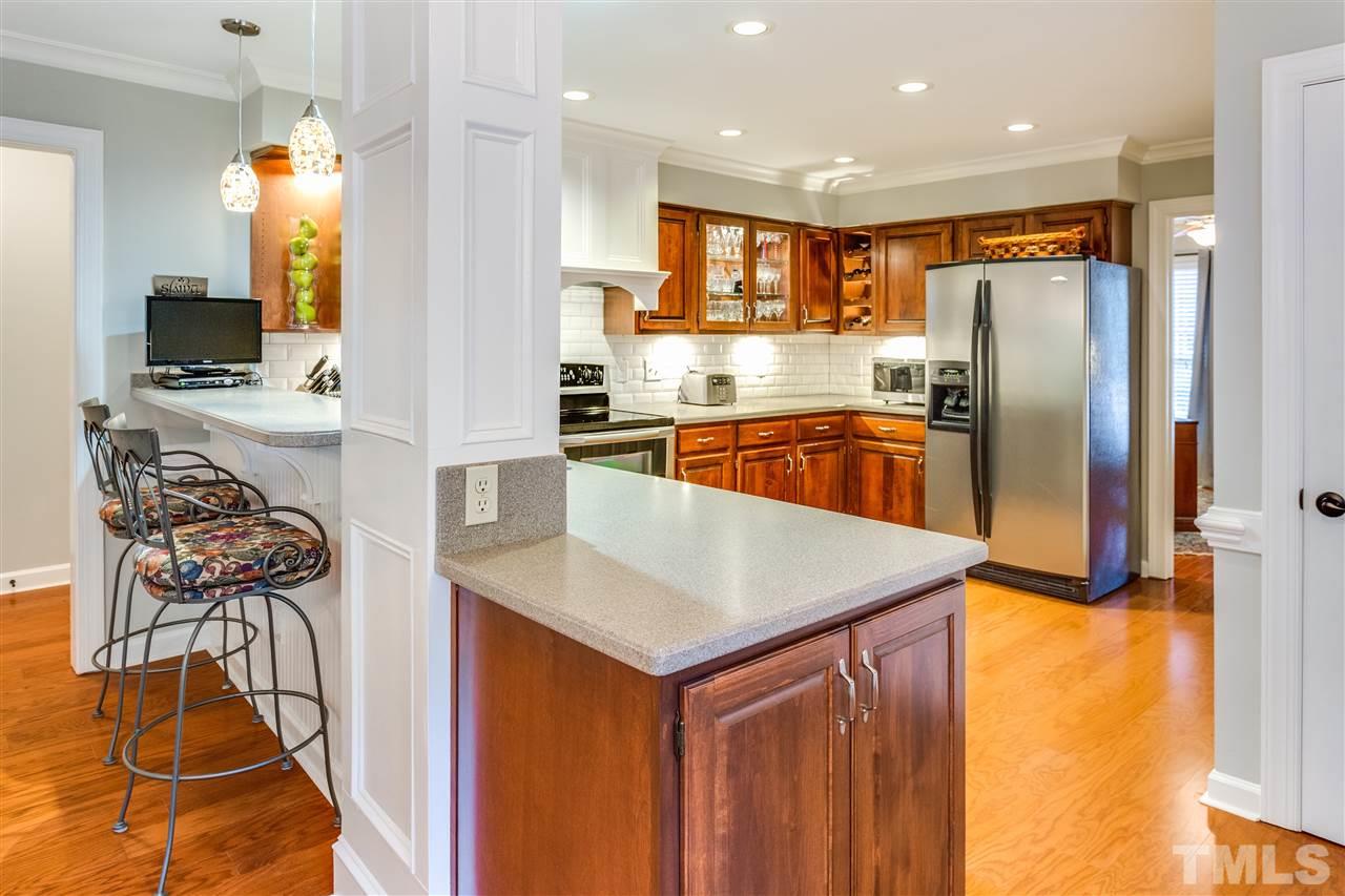 2020 Torrington Street Raleigh, NC 27615 - Photo 6 of 25 a kitchen with stainless steel appliances granite countertop a refrigerator a stove and a sink with wooden floor