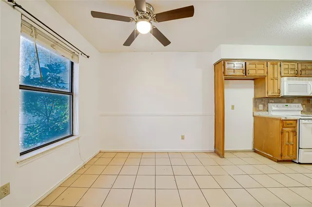 view of an empty room with a window and dresser
