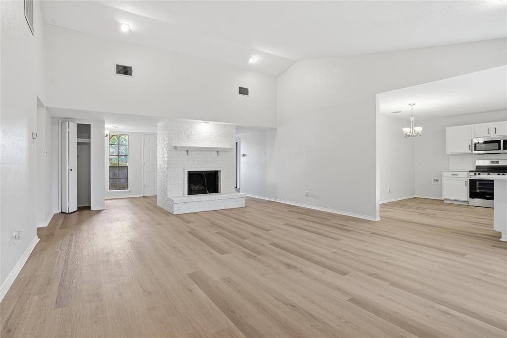 403 Redbud Drive Forney, TX 75126 - Photo 5 of 17 an empty room with wooden floor and fireplace
