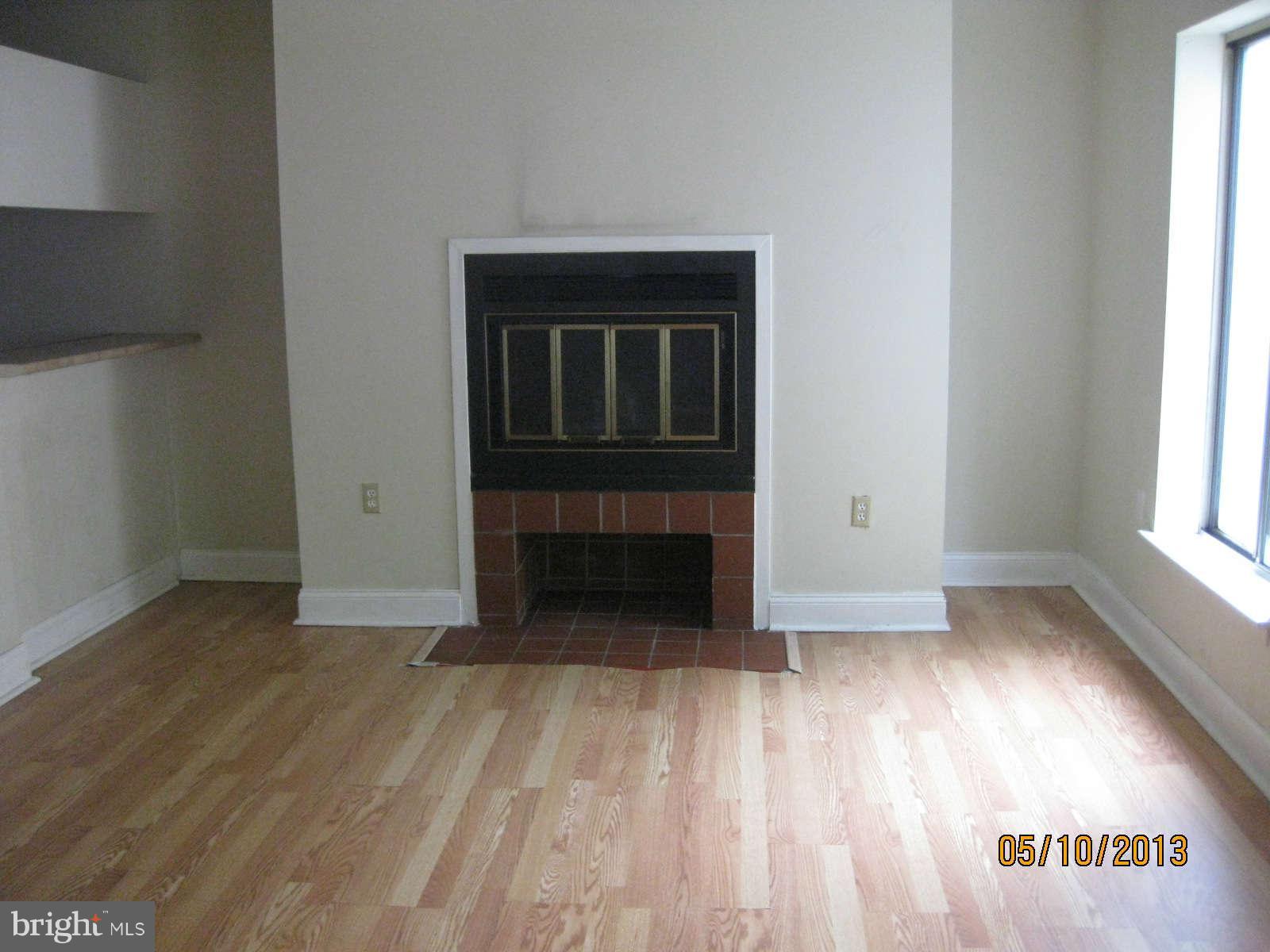 512 Charles Street, Unit R90 Baltimore, MD 21201 - Photo 3 of 10 a view of empty room with wooden floor and fireplace