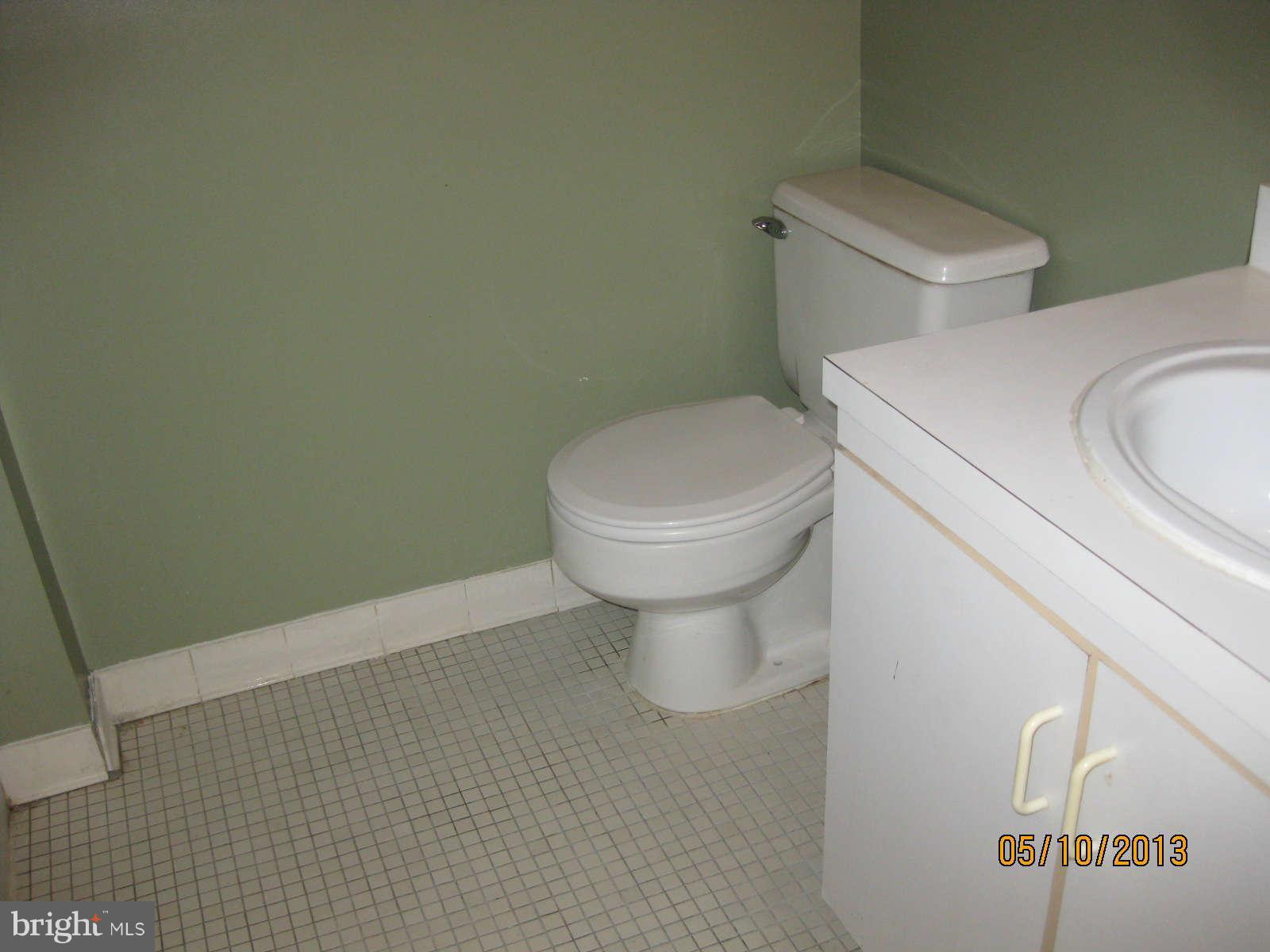 512 Charles Street, Unit R90 Baltimore, MD 21201 - Photo 9 of 10 a white toilet sitting next to a white sink and vanity