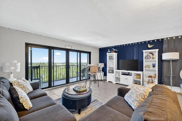 a living room with furniture a large window and a flat screen tv