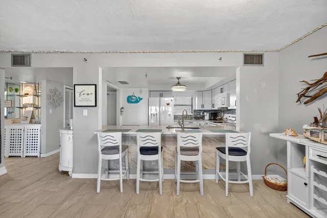 a kitchen with stainless steel appliances kitchen island granite countertop a table and chairs in it