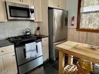 a kitchen with stainless steel appliances a stove a microwave a sink and cabinets