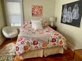 a bedroom with a bed and a painting on the wall