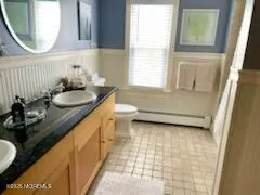 a bathroom with a granite countertop sink a toilet and a mirror