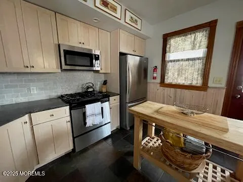 a kitchen with stainless steel appliances granite countertop a stove a sink dishwasher and a refrigerator with wooden floor