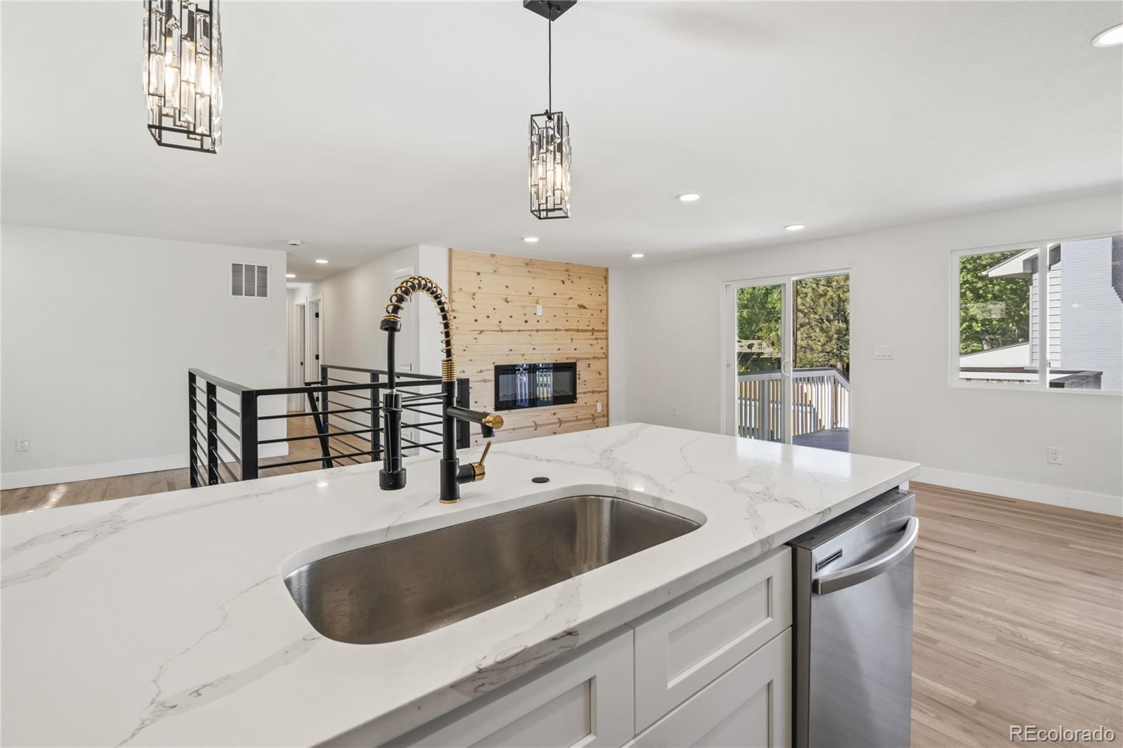 3495 Miller Street Wheat Ridge, CO 80033 - Photo 12 of 40 a kitchen with stainless steel appliances granite countertop a sink and a wooden floor