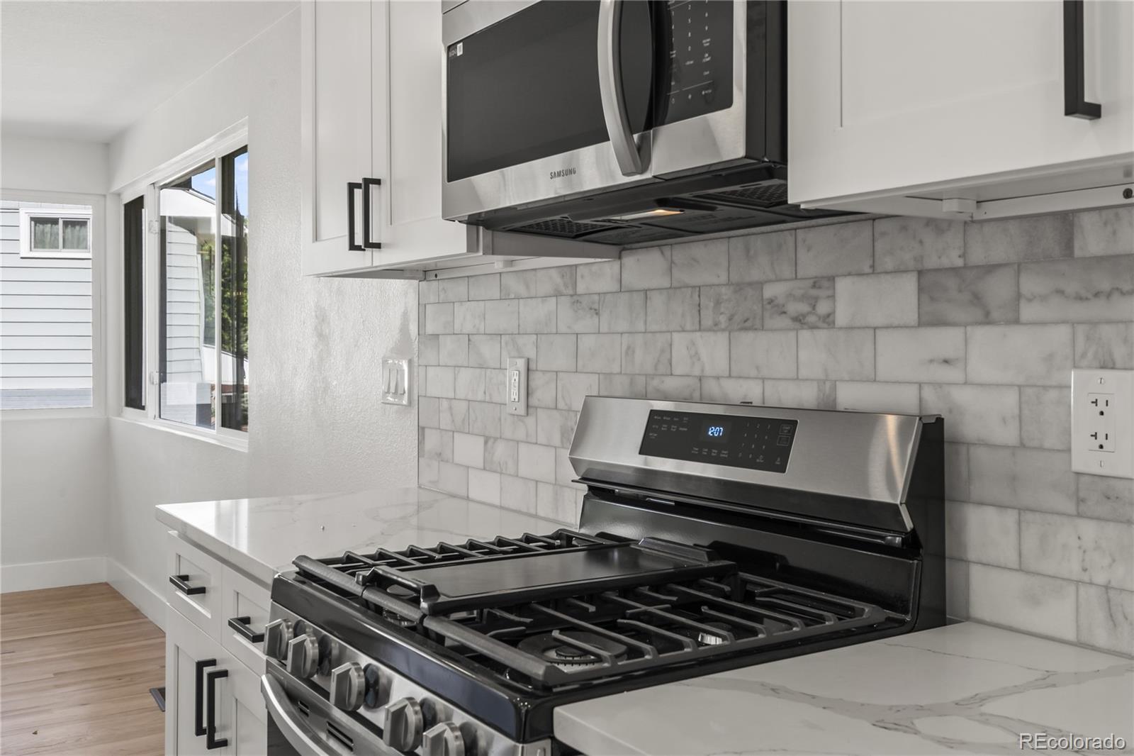 3495 Miller Street Wheat Ridge, CO 80033 - Photo 13 of 40 a stove top oven sitting inside of a kitchen