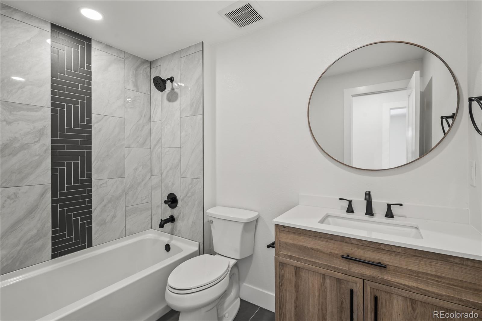 3495 Miller Street Wheat Ridge, CO 80033 - Photo 17 of 40 a bathroom with a sink a toilet and a mirror