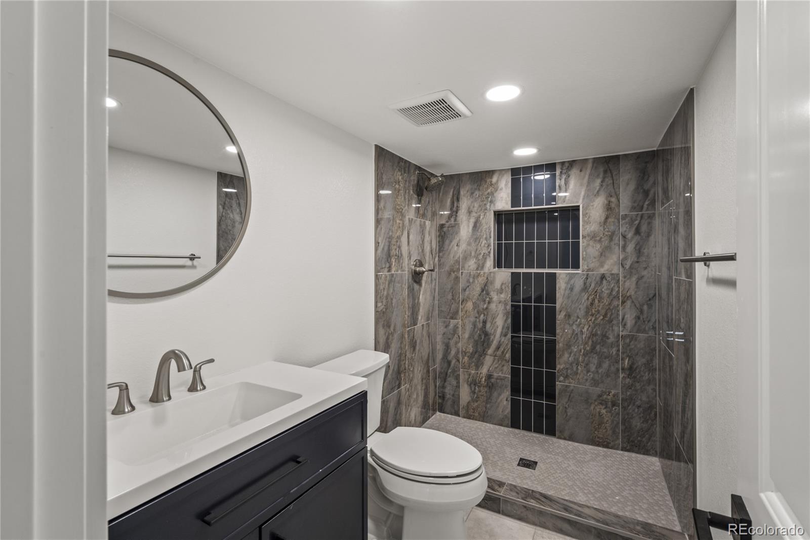 3495 Miller Street Wheat Ridge, CO 80033 - Photo 29 of 40 a bathroom with a sink toilet a mirror and shower