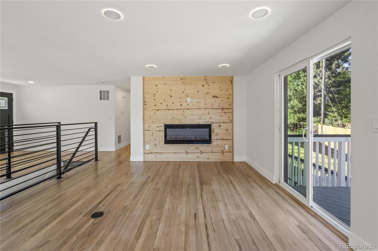 3495 Miller Street Wheat Ridge, CO 80033 - Photo 30 of 40 an empty room with wooden floor fireplace and windows