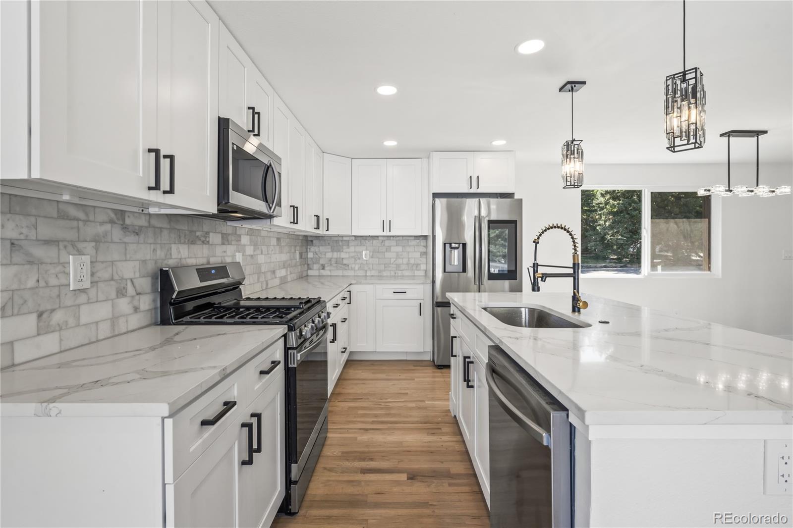 3495 Miller Street Wheat Ridge, CO 80033 - Photo 10 of 40 a kitchen with stainless steel appliances granite countertop a sink stove and refrigerator