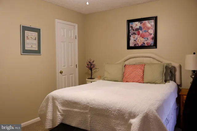 a bedroom with a bed and painting on the wall