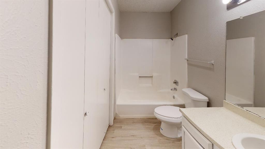 9696 Walnut Street, Unit 1006 Dallas, TX 75243 - Photo 5 of 6 a bathroom with a toilet sink vanity and shower