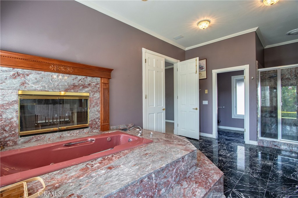 46856 El Prado Road Temecula, CA 92590 - Photo 33 of 75 a spacious bedroom with a bed and a fireplace