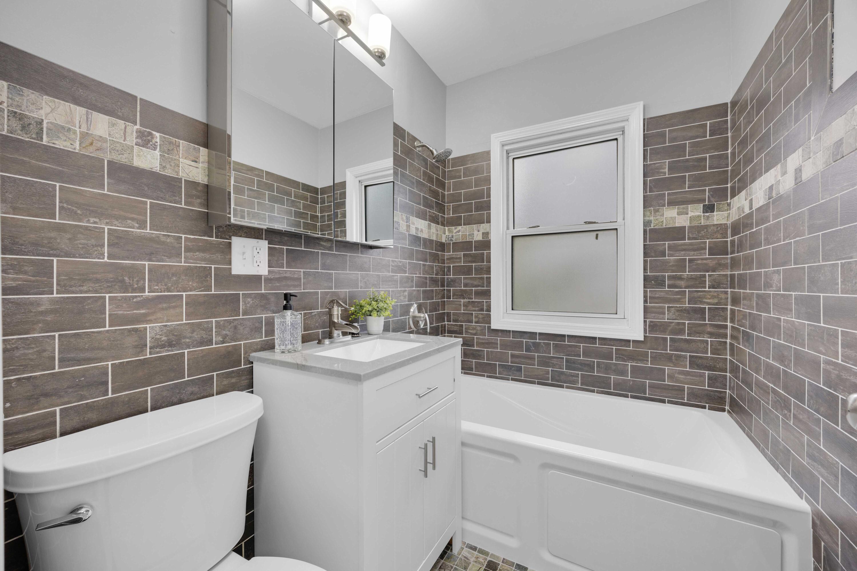 125 Marshall Street Gary, IN 46404 - Photo 13 of 23 a bathroom with a sink a toilet a mirror a bathtub and shower