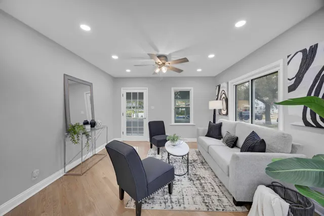 a living room with furniture two window and a table