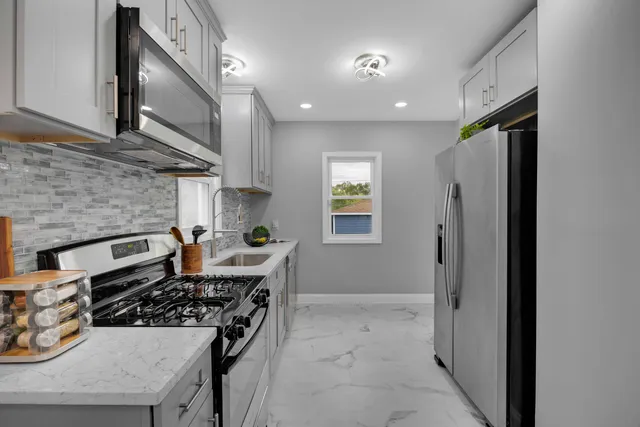 a kitchen with stainless steel appliances granite countertop a stove and a refrigerator