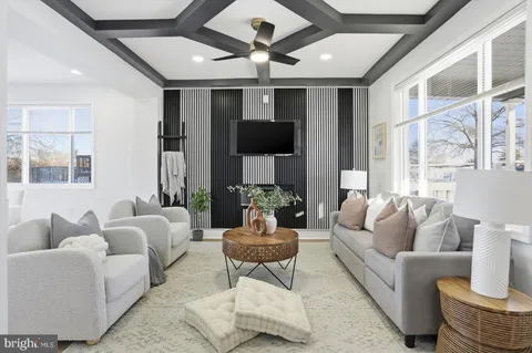 a living room with furniture a chandelier and a large window