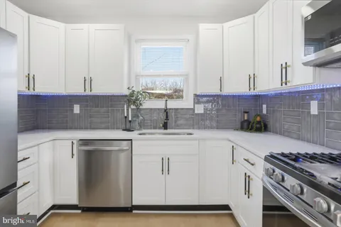 a kitchen with white cabinets and appliances