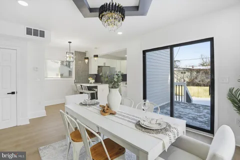 a view of a dining room with furniture a chandelier and wooden floor