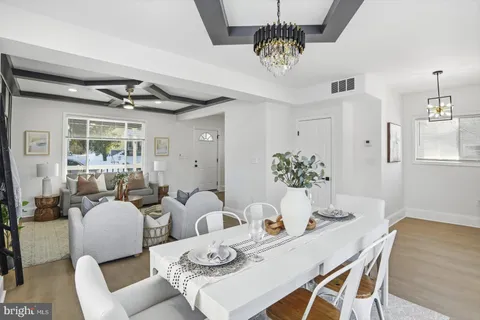 a view of a livingroom and dining room with furniture wooden floor and a chandelier