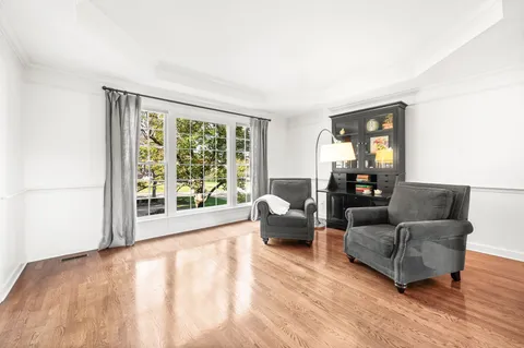a view of a dining room with furniture a chandelier and wooden floor