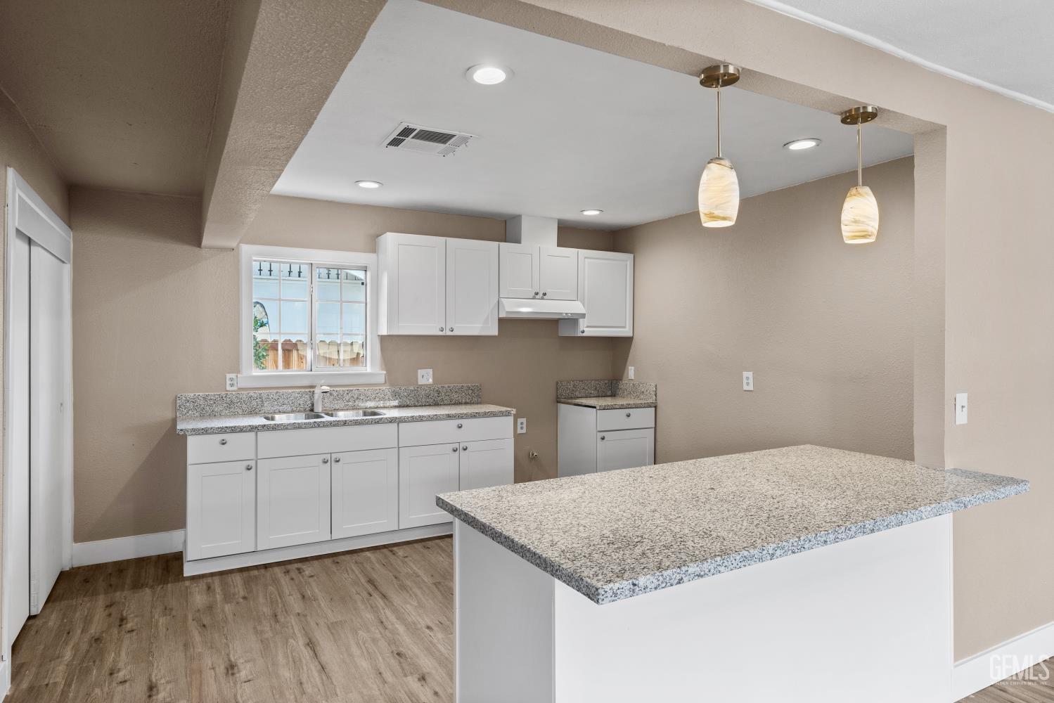Undisclosed Address Bakersfield, CA 93305 - Photo 11 of 32 a kitchen with granite countertop a sink cabinets and wooden floor
